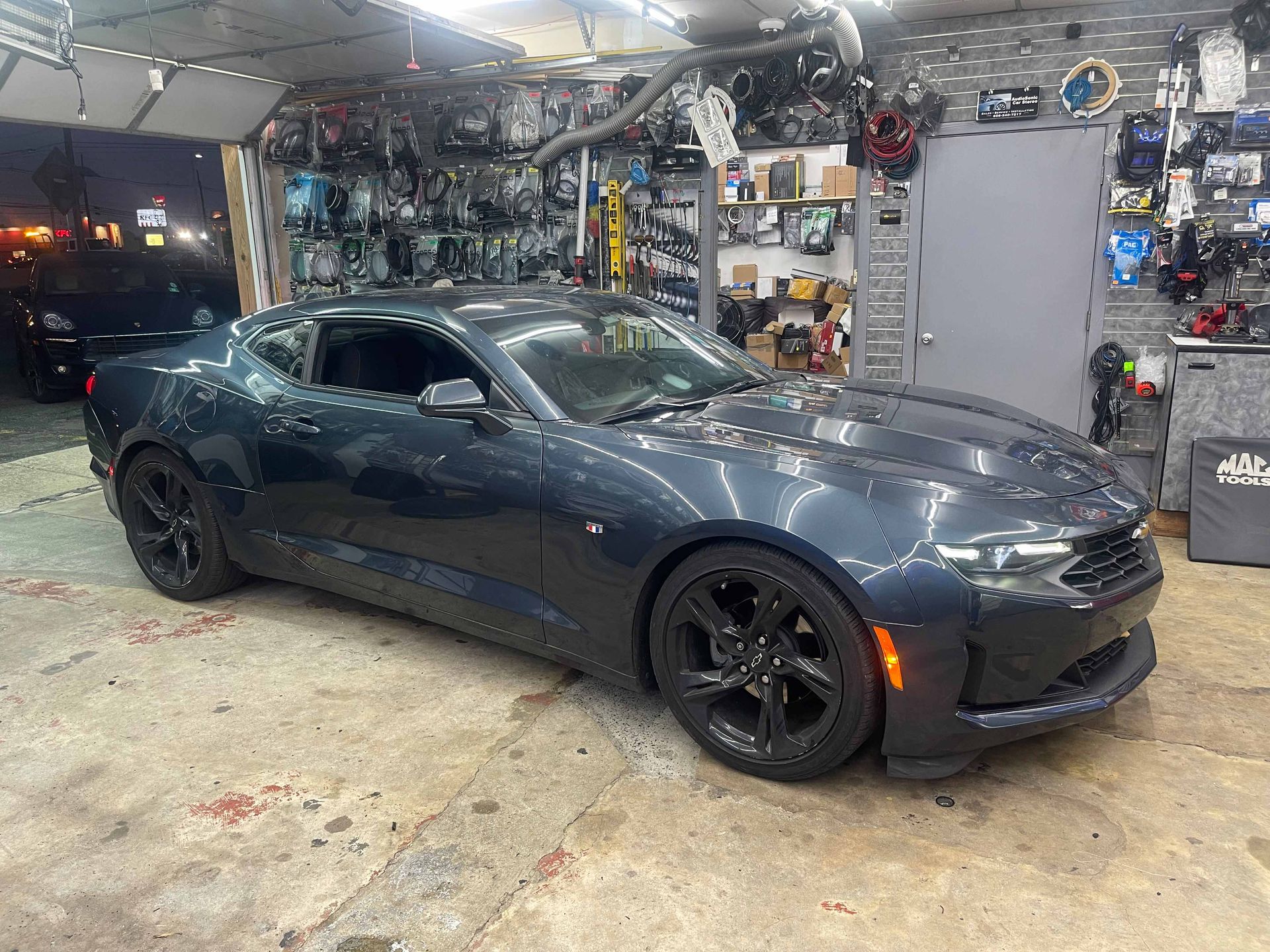 A black sports car is parked in a garage.