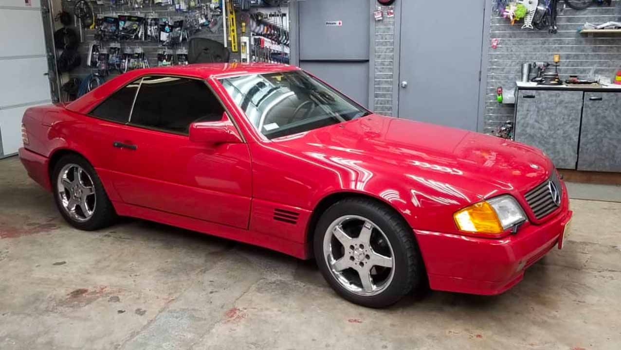 A red sports car is parked in a garage.