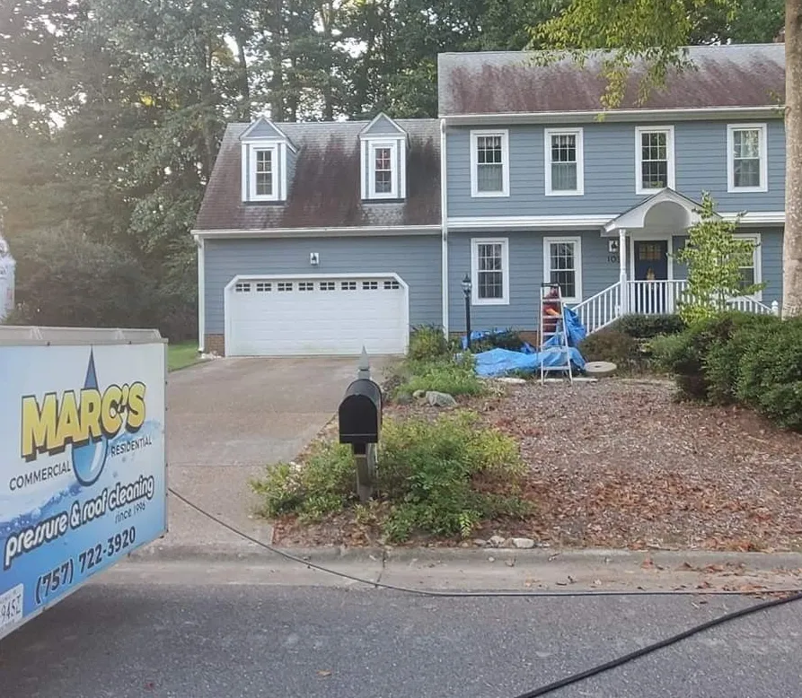 Suburban house with a moving sign in the yard and a person near the front steps