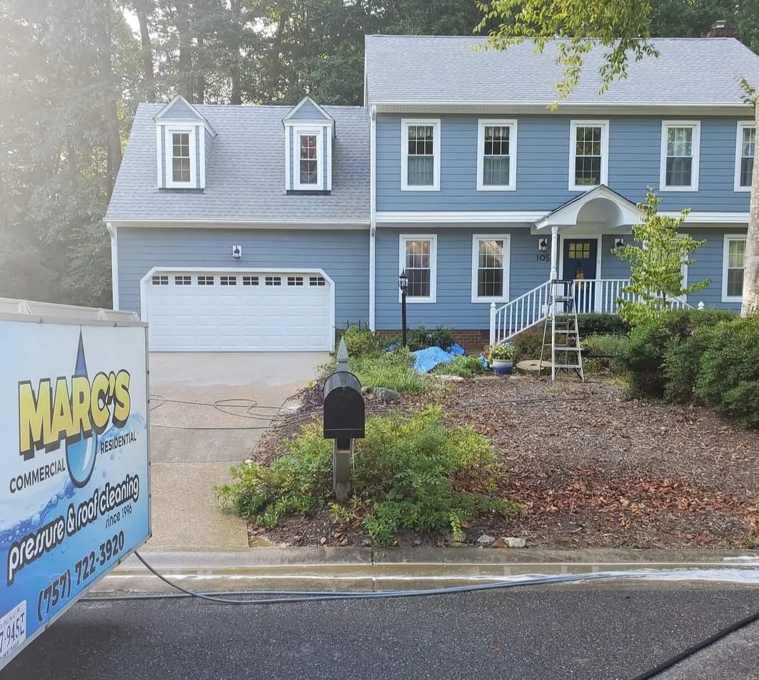 Blue two-story house with garage and a delivery sign in the front yard