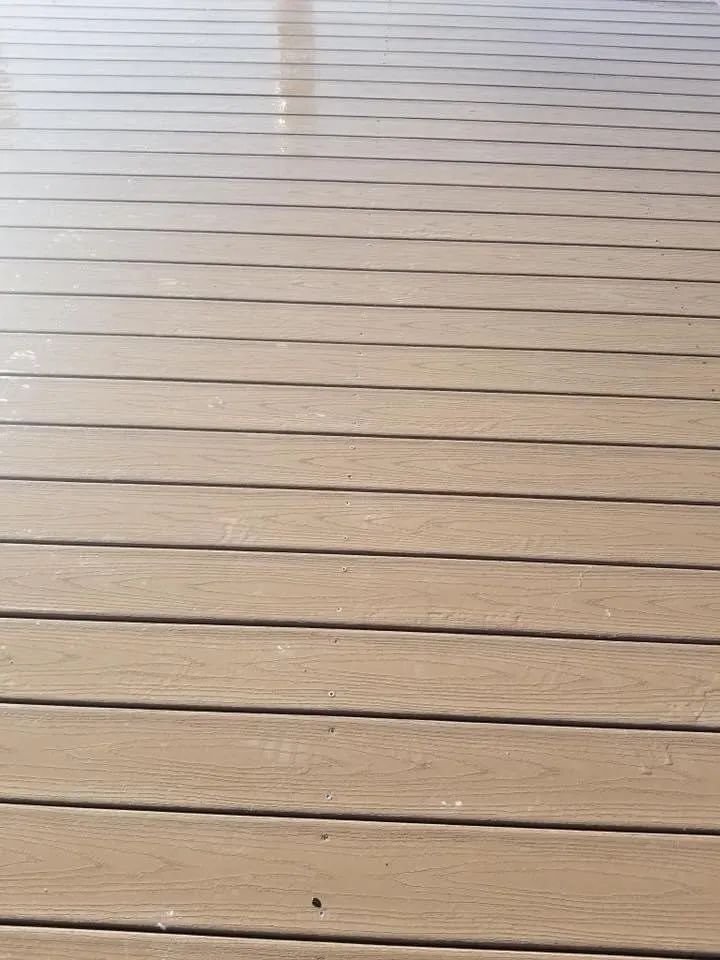 Wooden deck boards with a thin line of water reflecting light at the top.