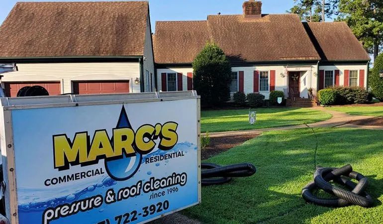 Marc’s Commercial pressure wash cleaning sign on a lawn in front of suburban houses