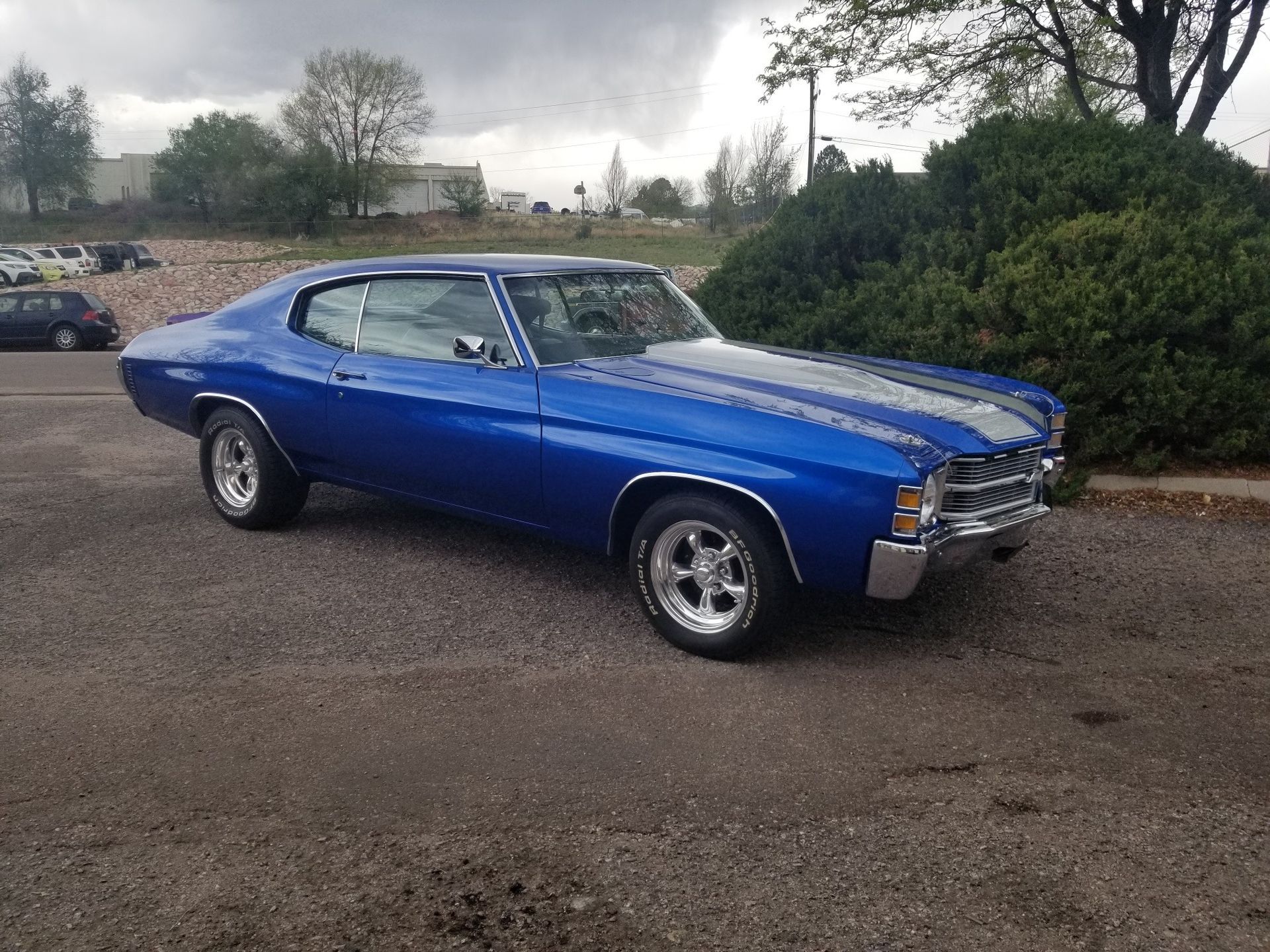 Blue Chevrolet Chevelle parked outdoors with white racing stripes.
