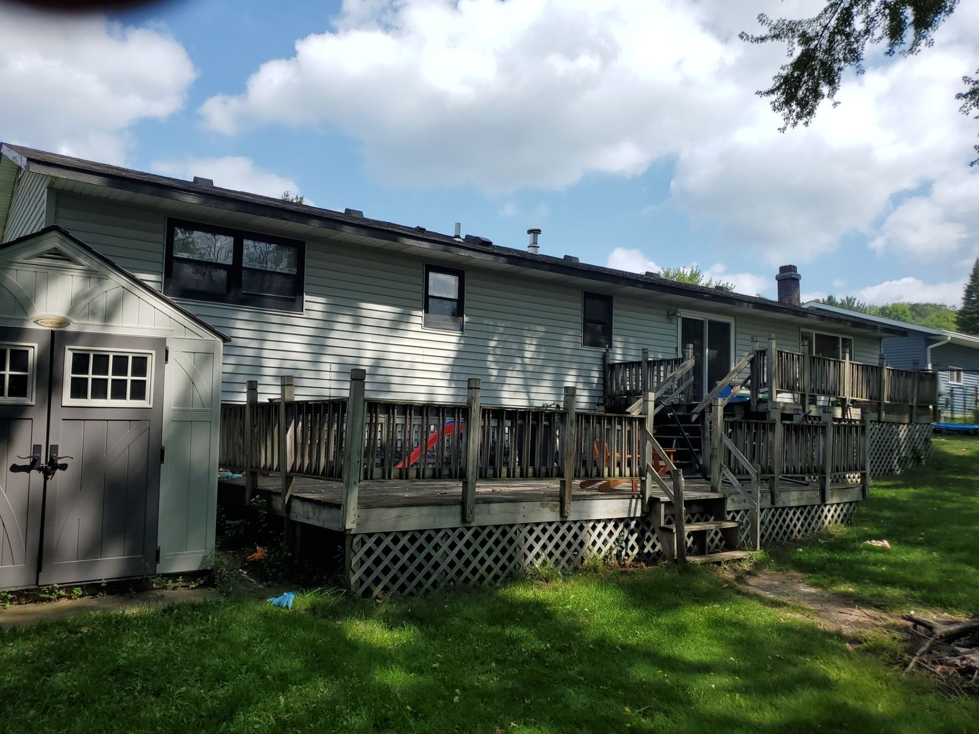 The back of a house with a large deck and a garage.