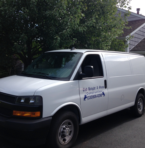 White cargo van parked on a residential street with a company logo on the side