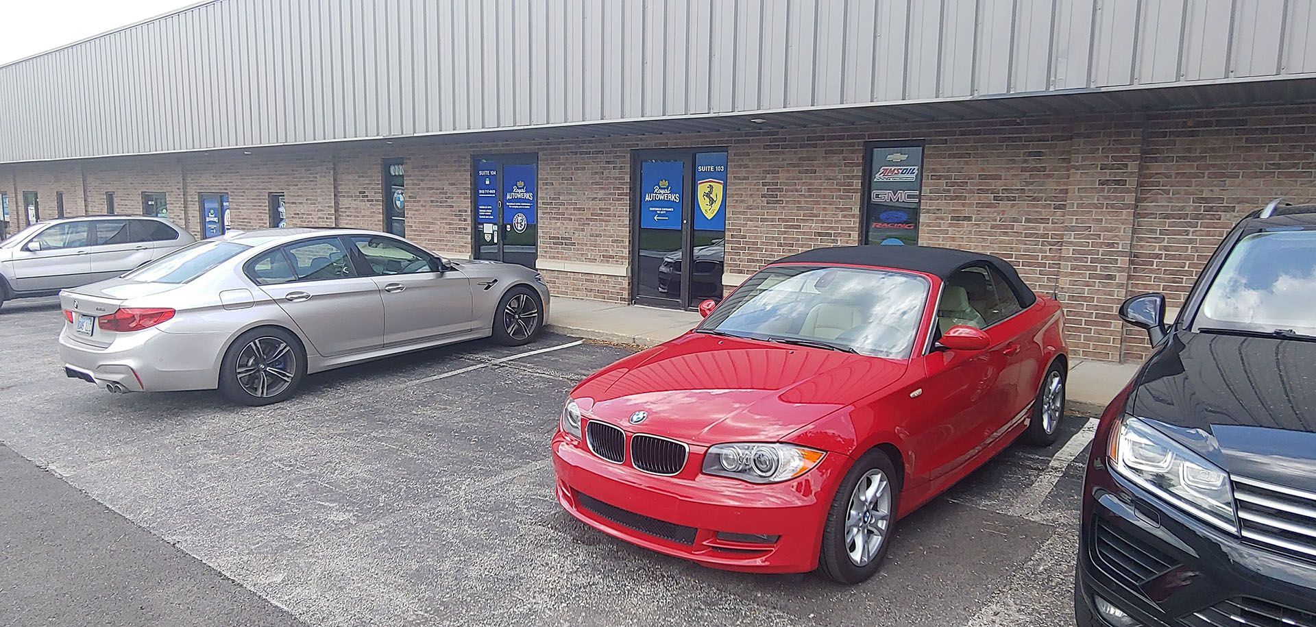 A red car is parked in front of a building.