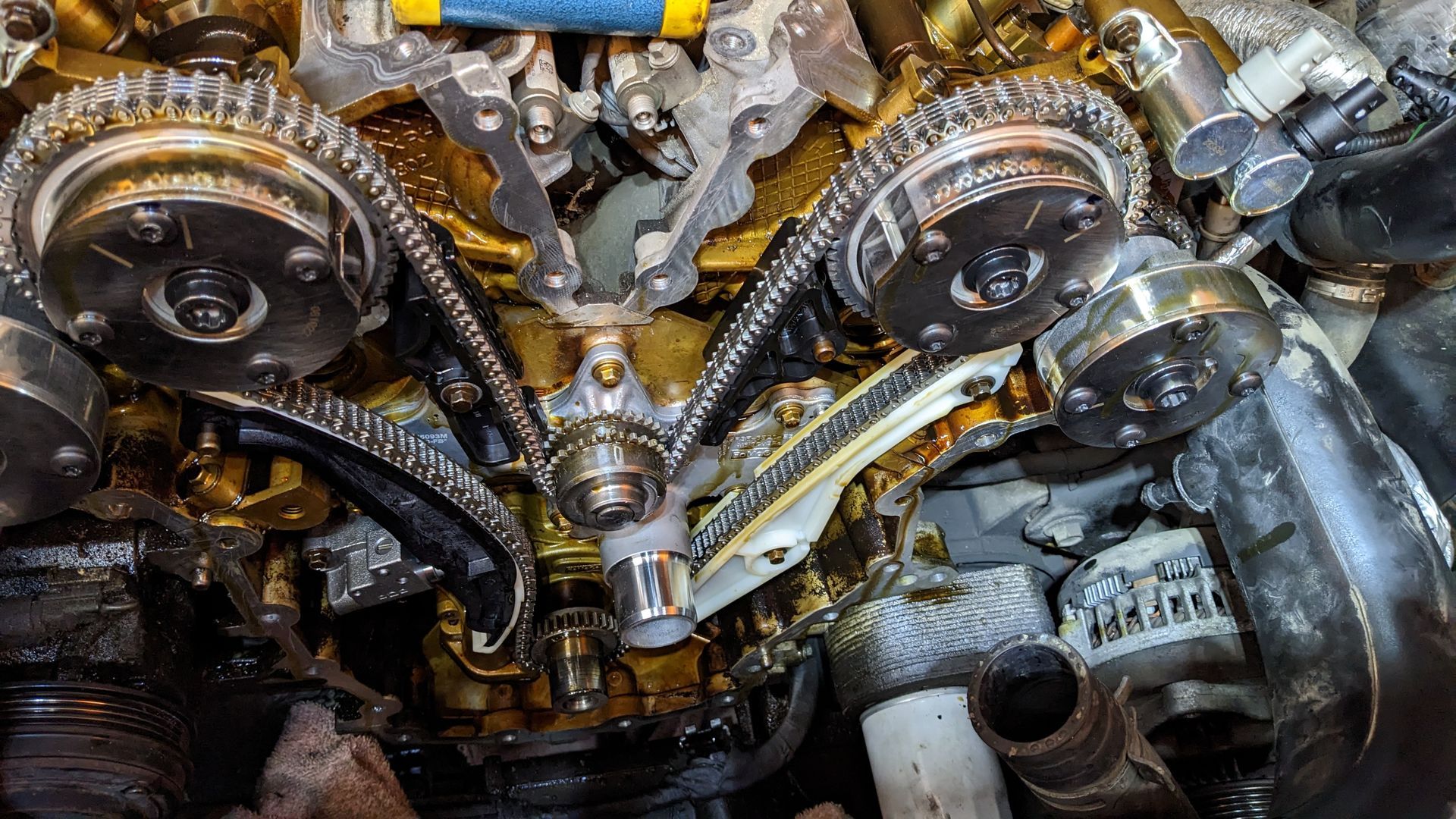 A close up of a car engine with chains and gears.