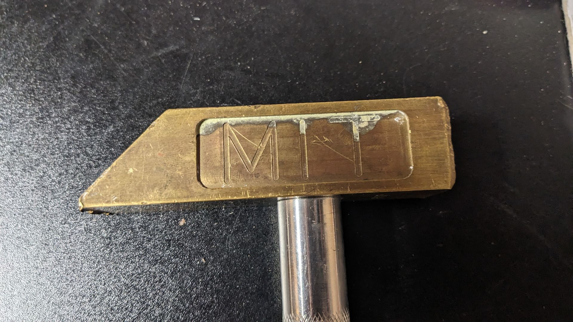 A hammer with the letter m on it