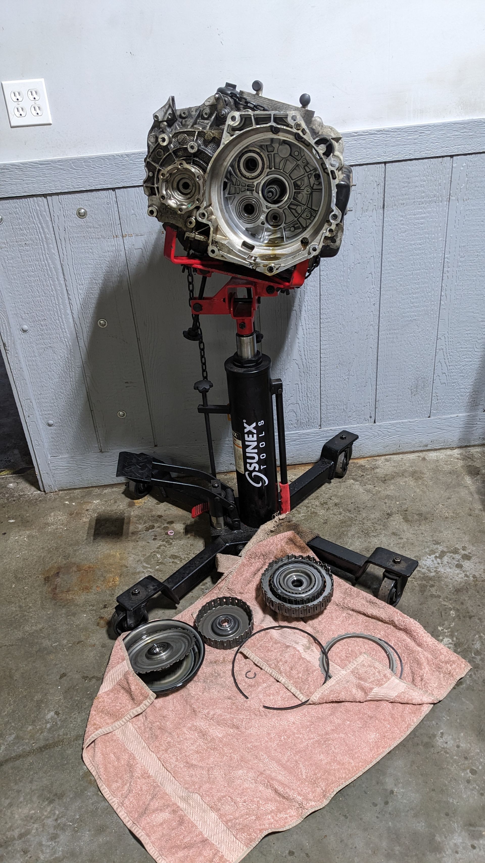A gearbox is sitting on top of a towel on a stand.