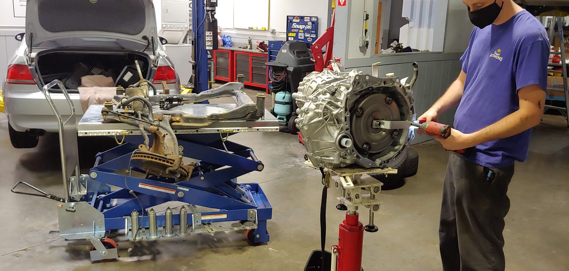 A man is working on a car engine in a garage.