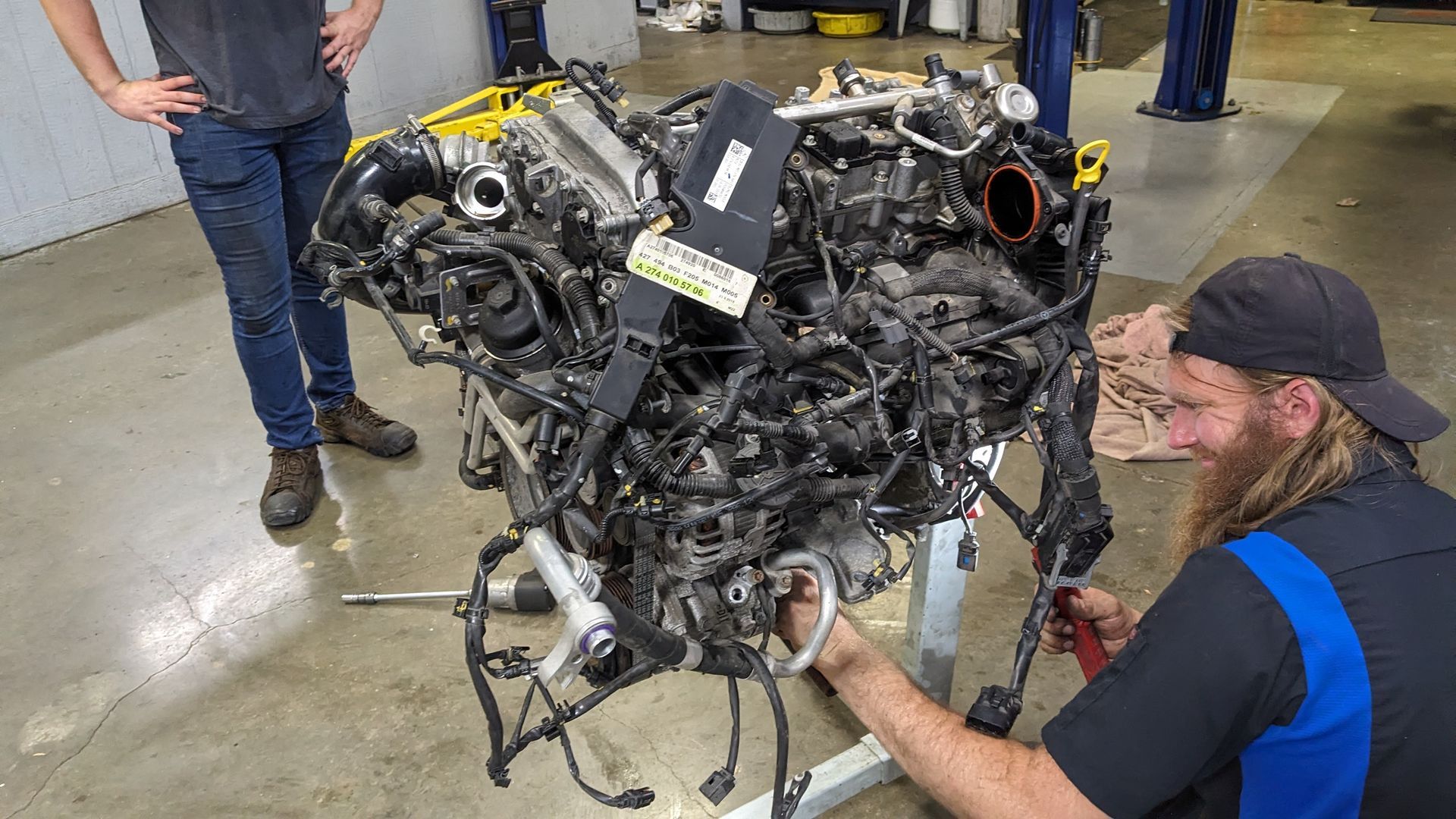 A man is working on a car engine in a garage.