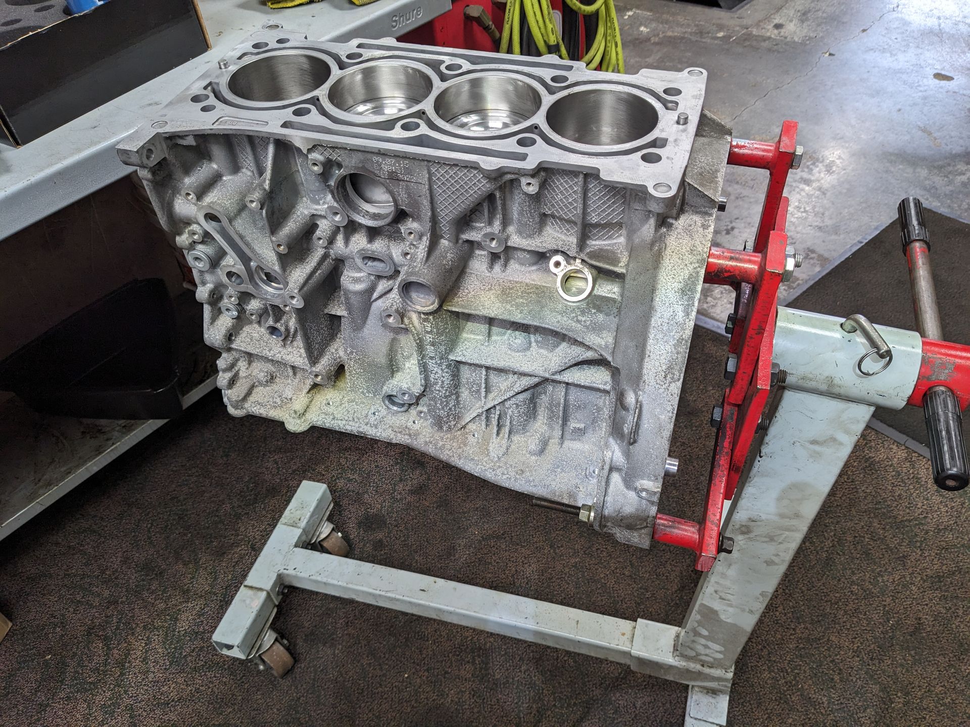 A block of a car engine is sitting on a stand.