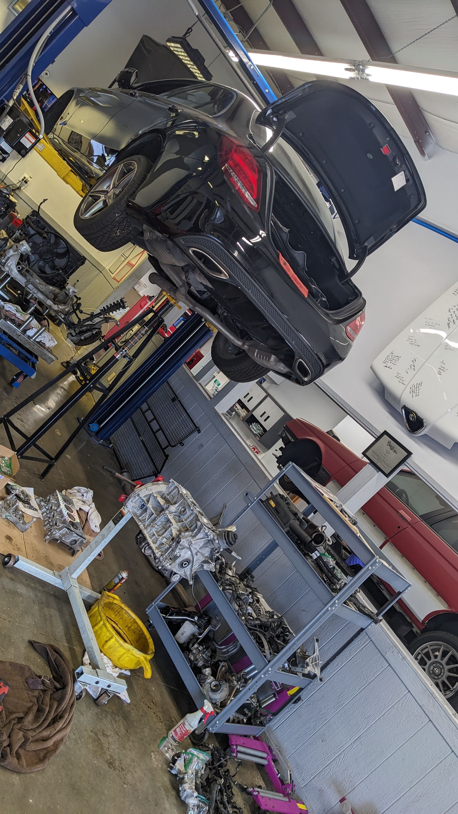 A car is sitting on a lift in a garage.