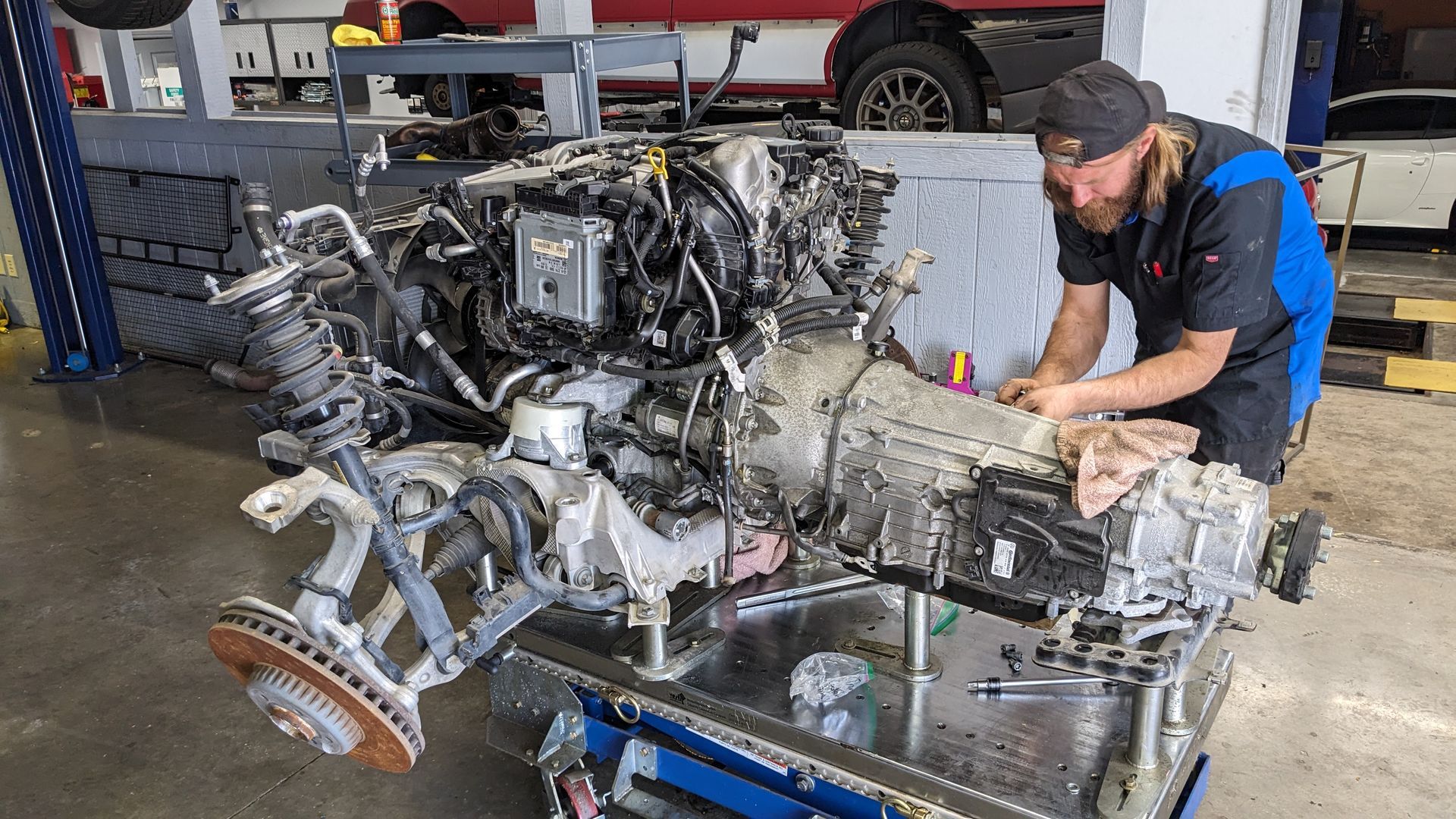 A man is working on a car engine in a garage.