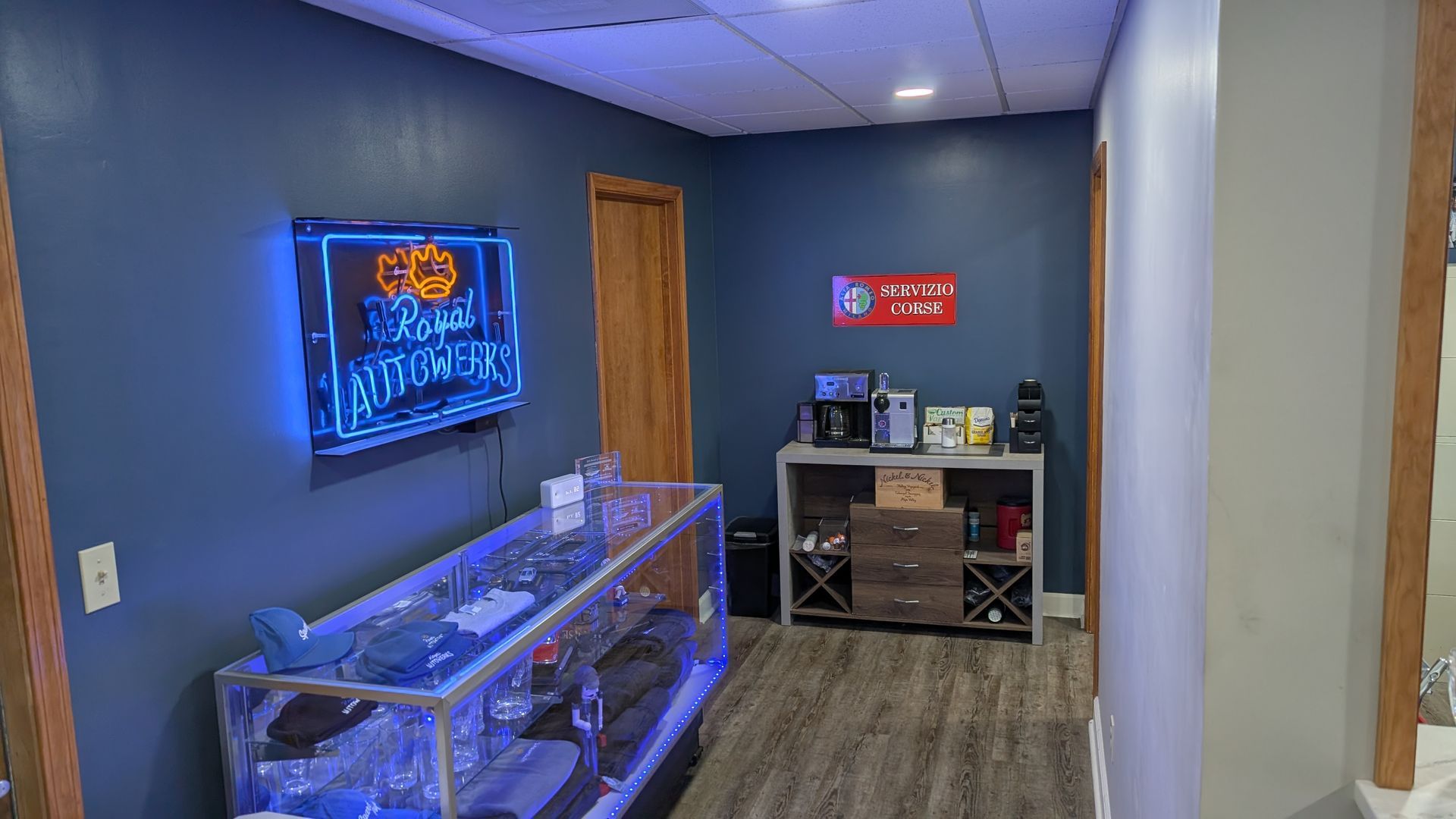 A room with a display case and a neon sign on the wall.