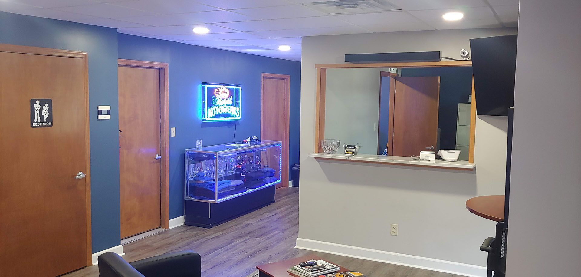 A living room with a chair , table , and television.