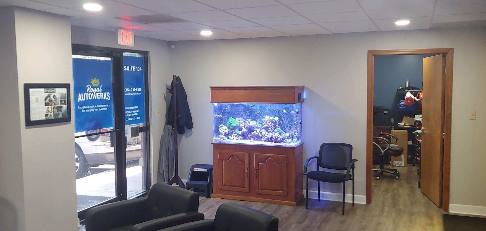 A waiting room with a large aquarium in the middle of it.