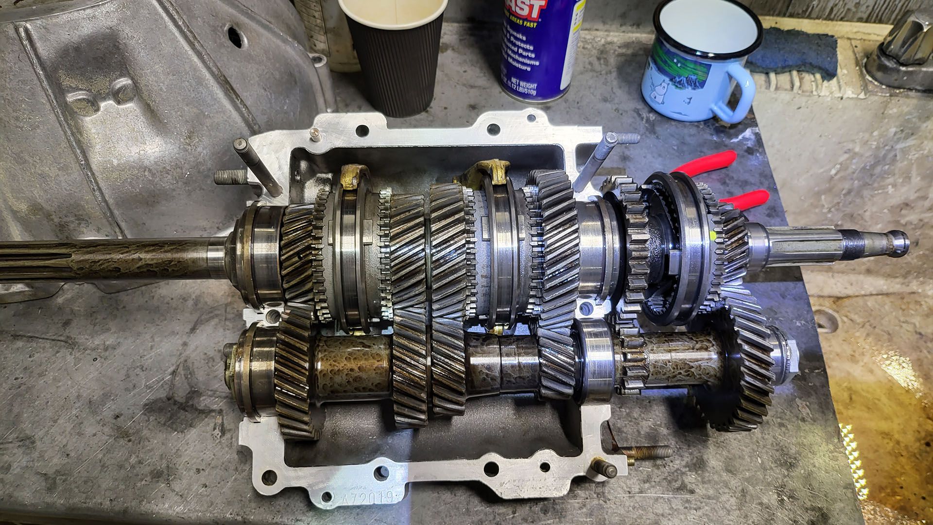 A gearbox is sitting on a table next to a cup of coffee.