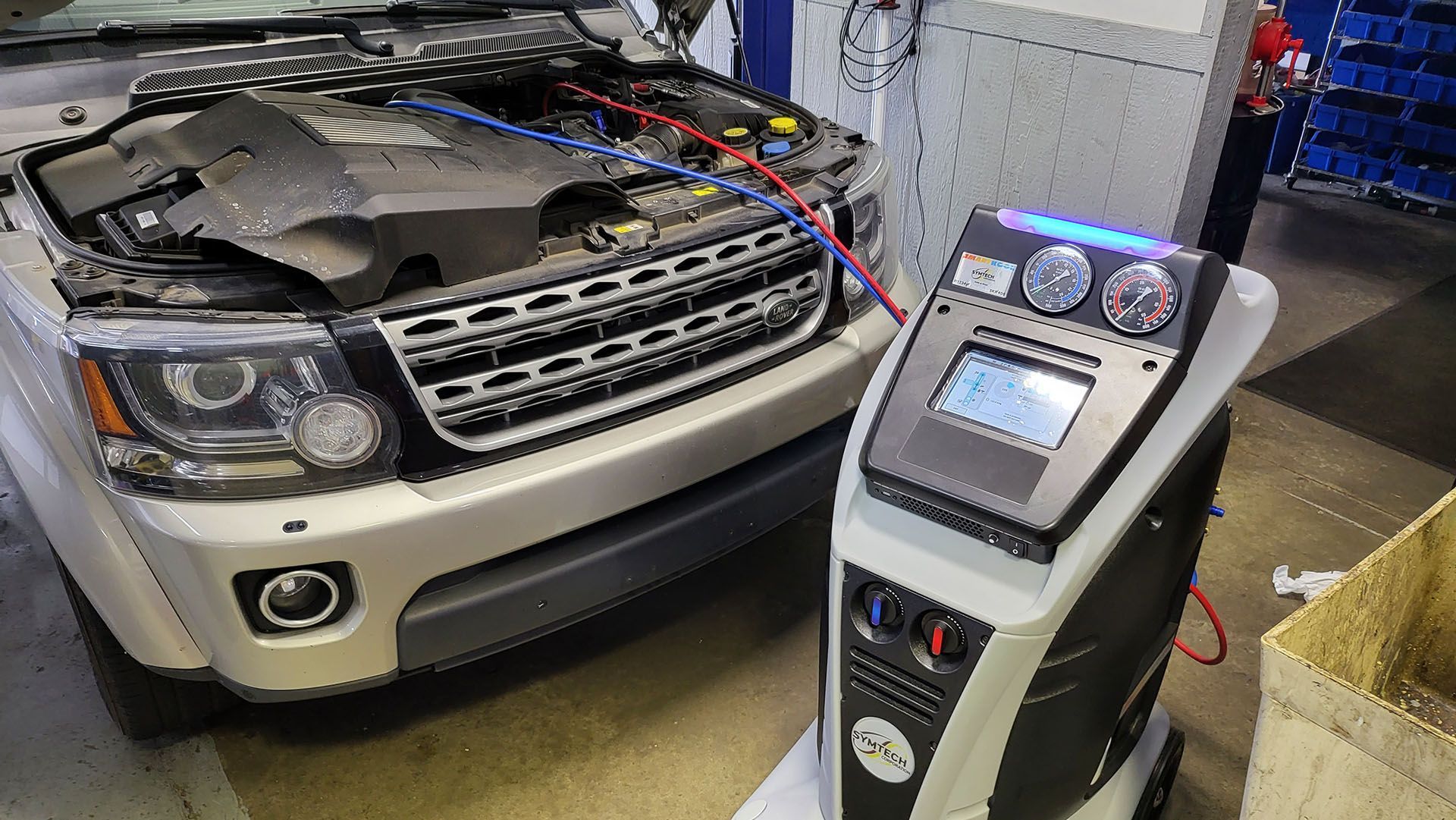 A range rover is being serviced by a machine in a garage.
