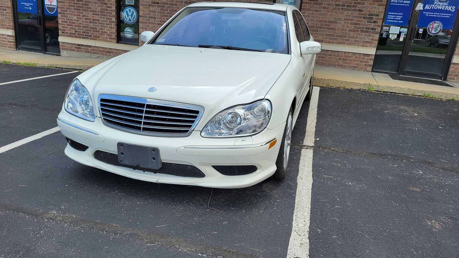 A white mercedes benz s class is parked in a parking lot.