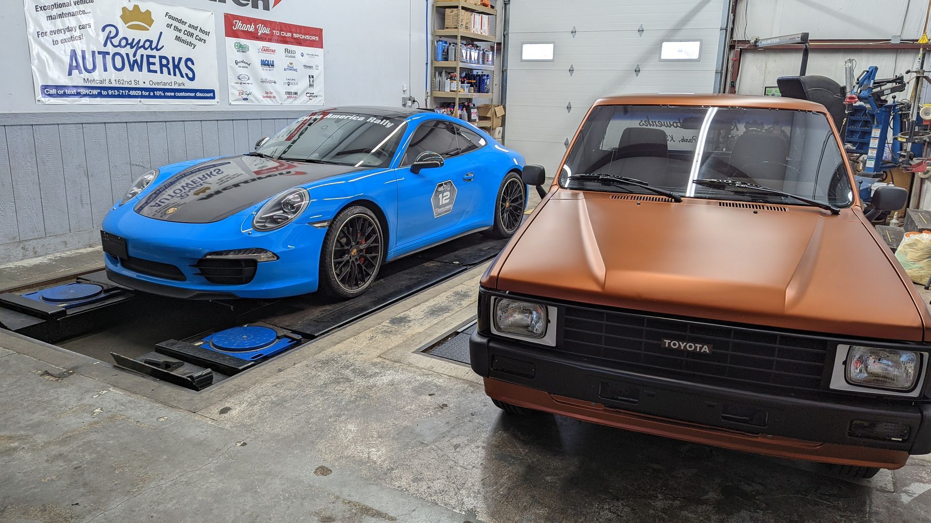 Two cars are parked next to each other in a garage.