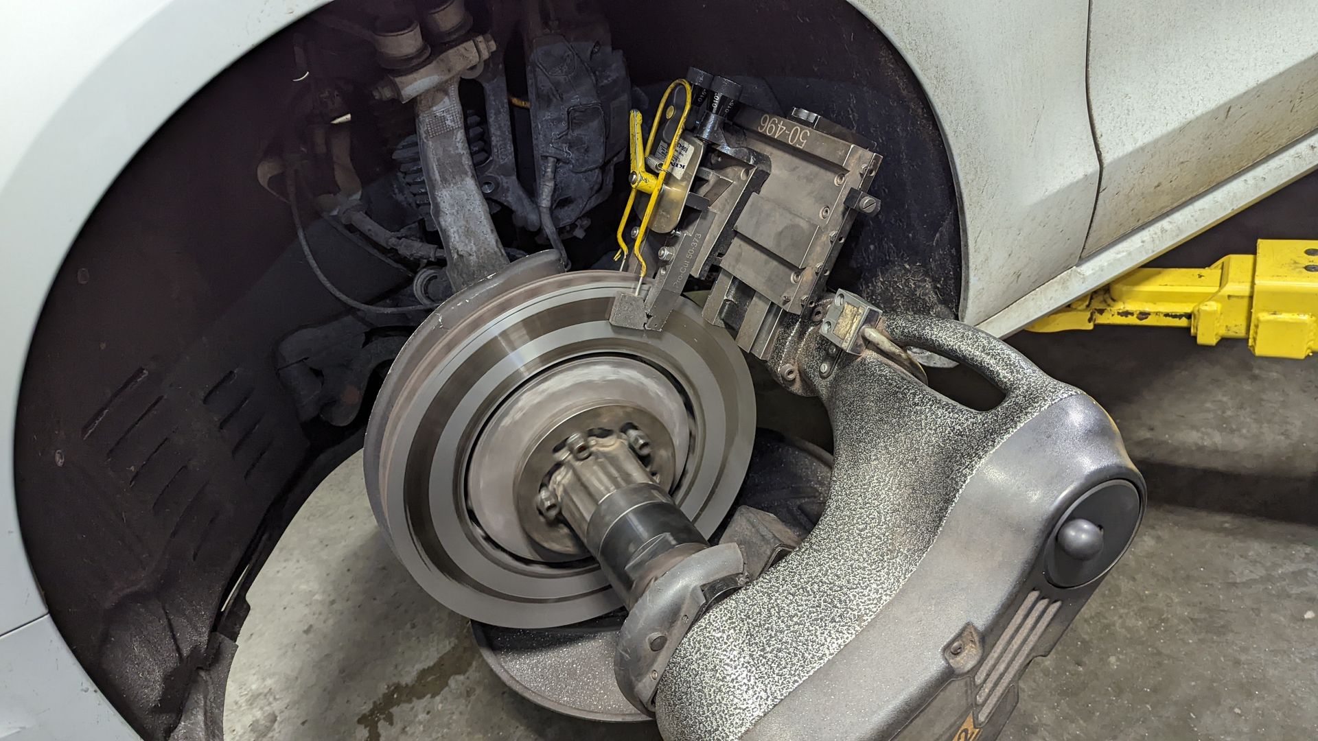 A car wheel is being worked on by a machine in a garage.