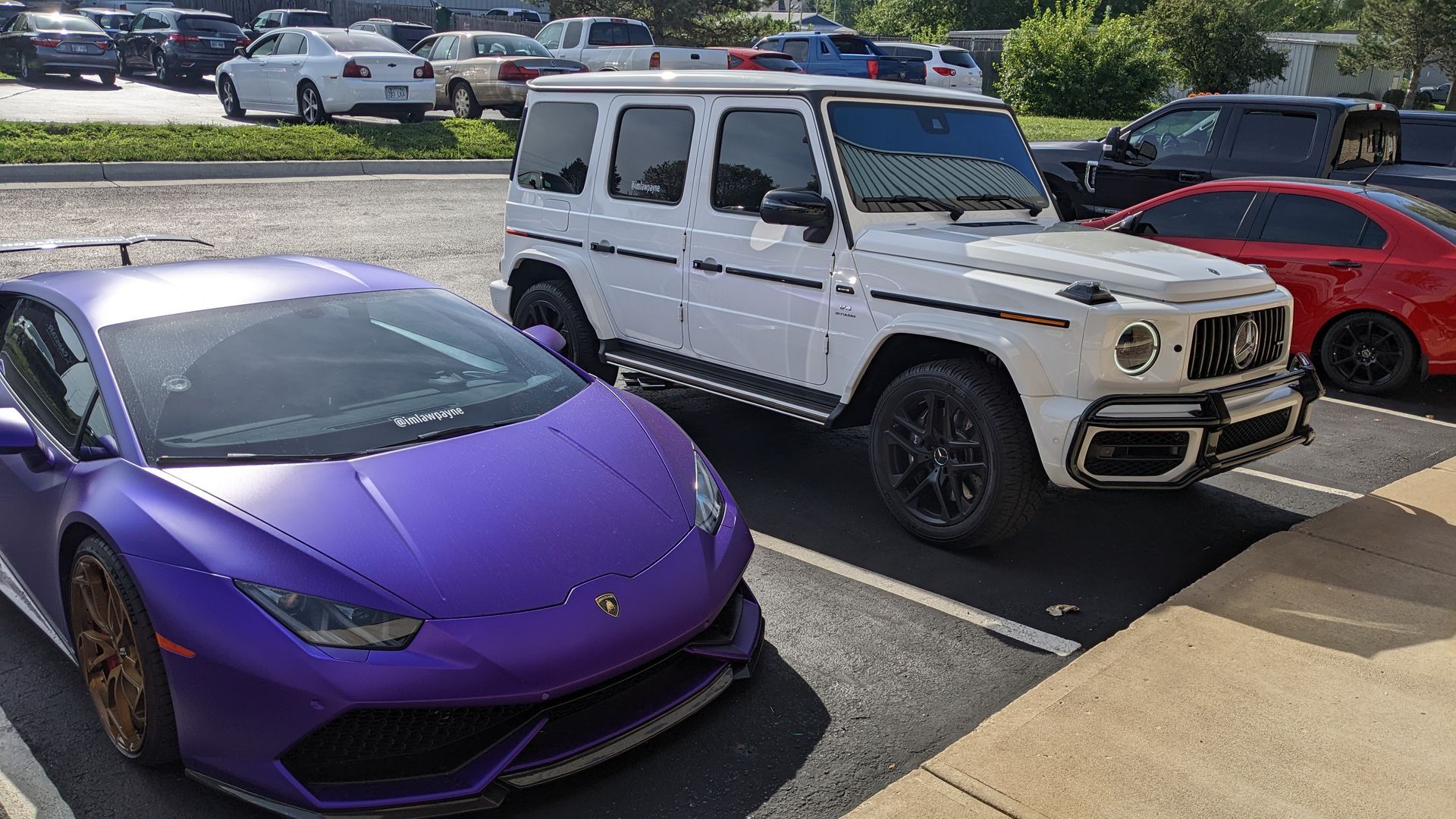 A purple lamborghini and a white jeep are parked next to each other in a parking lot.