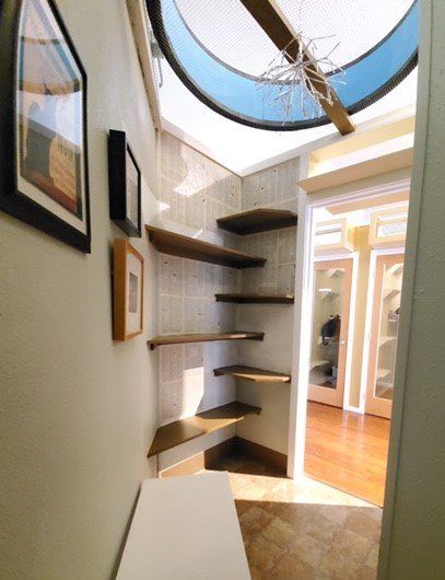 A hallway with shelves and pictures on the wall