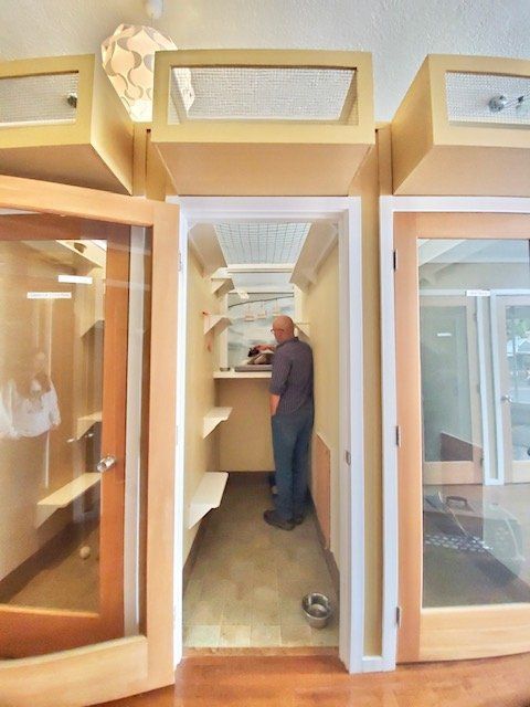 A man is standing in a small room between two doors