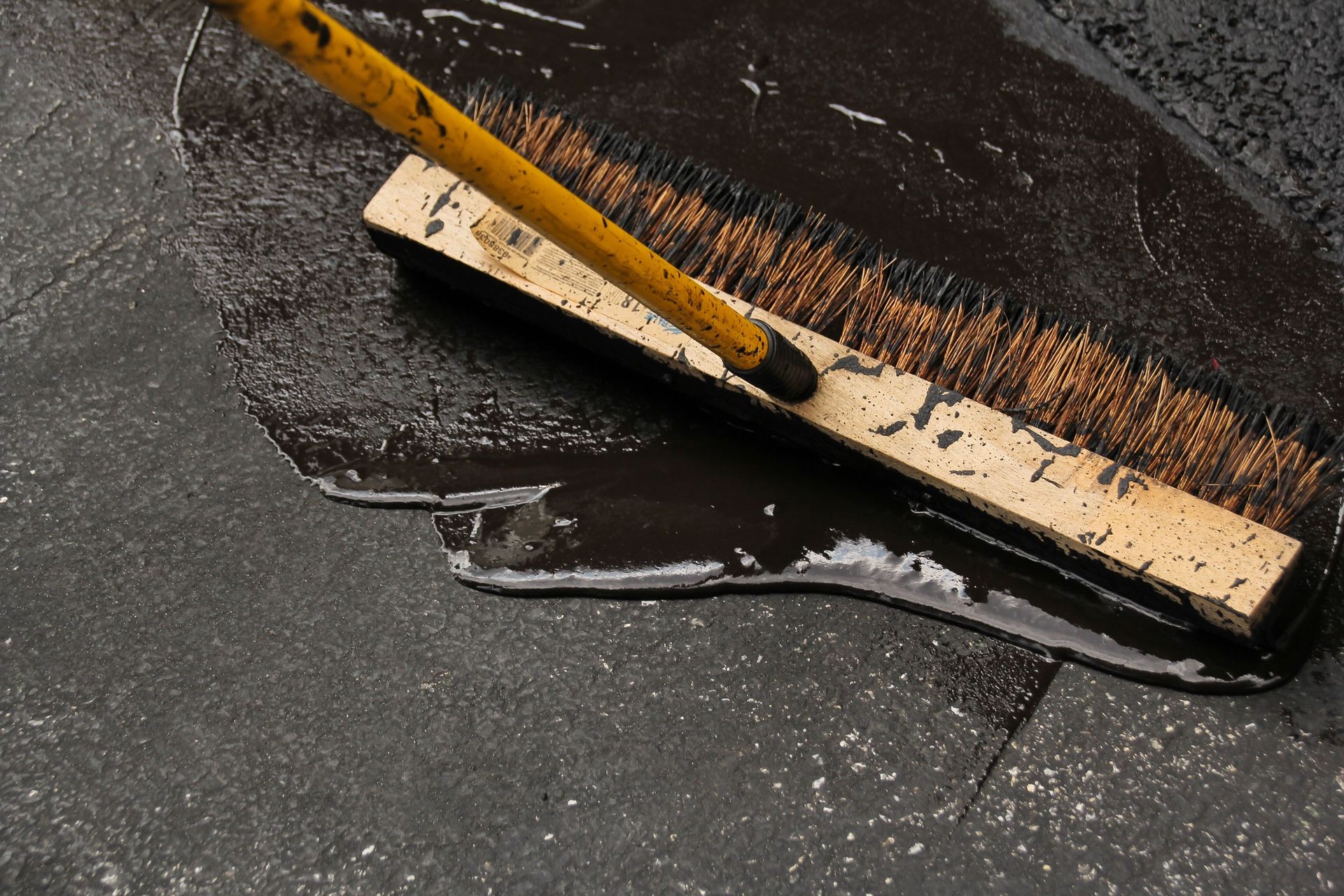 Floor squeegee pushing dark liquid across a wet floor