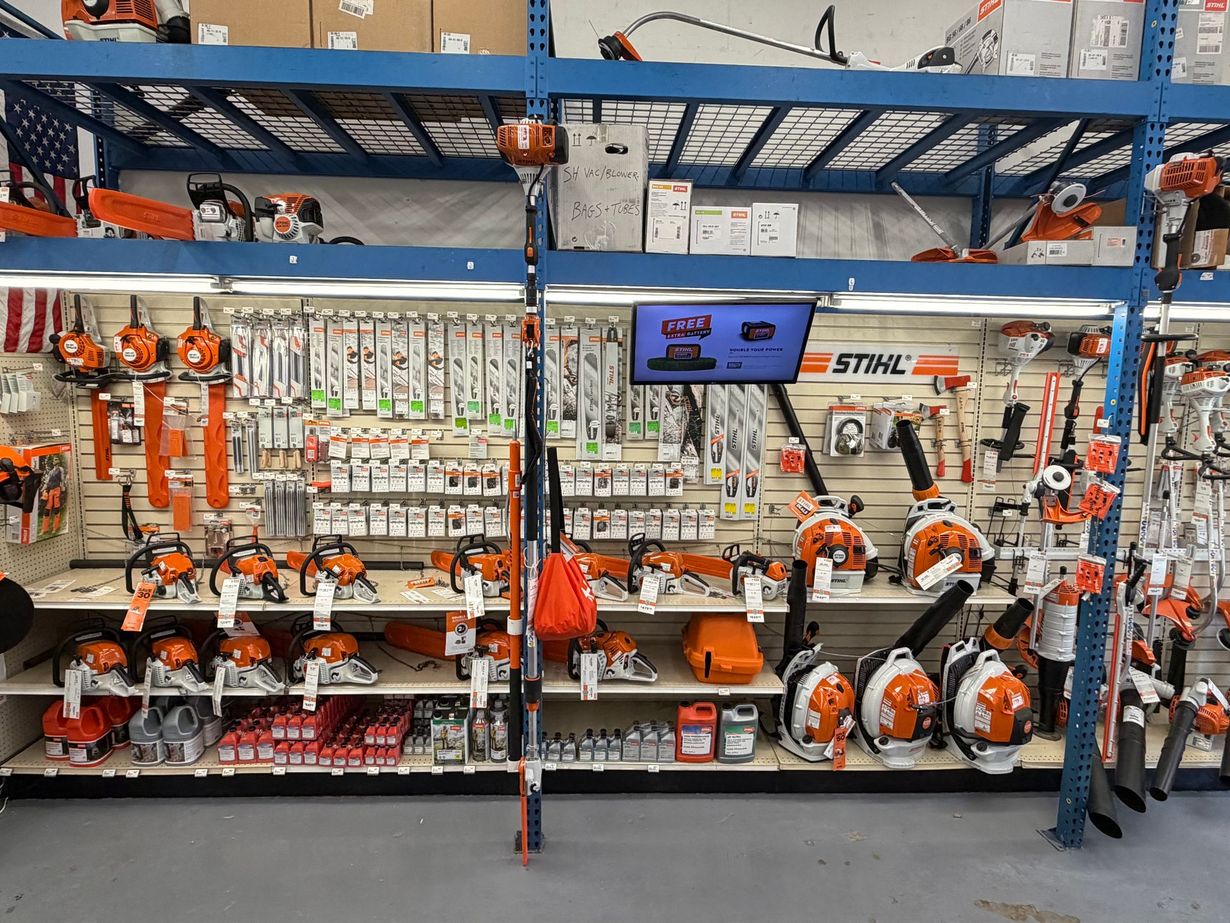 Shelves in a store displaying Stihl chainsaws, power equipment, and various tools and accessories.