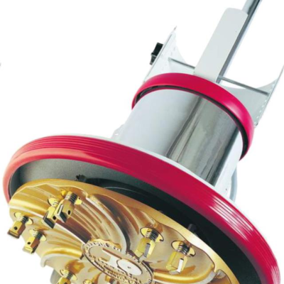 A close-up of a circular industrial grinding head with gold-colored metal blades, surrounded by a red protective rim.
