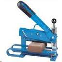 A blue manual brick splitter tool with a long handle, positioned over a rectangular brick on a flat surface.