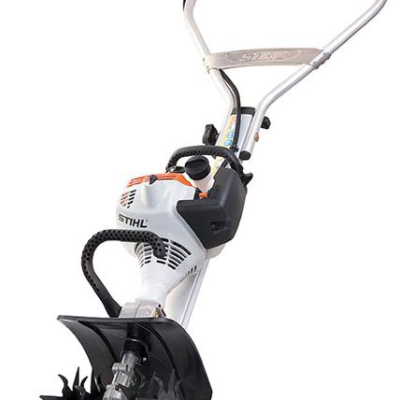 A white and orange Stihl garden tiller with metal tines and black handles against a white background.