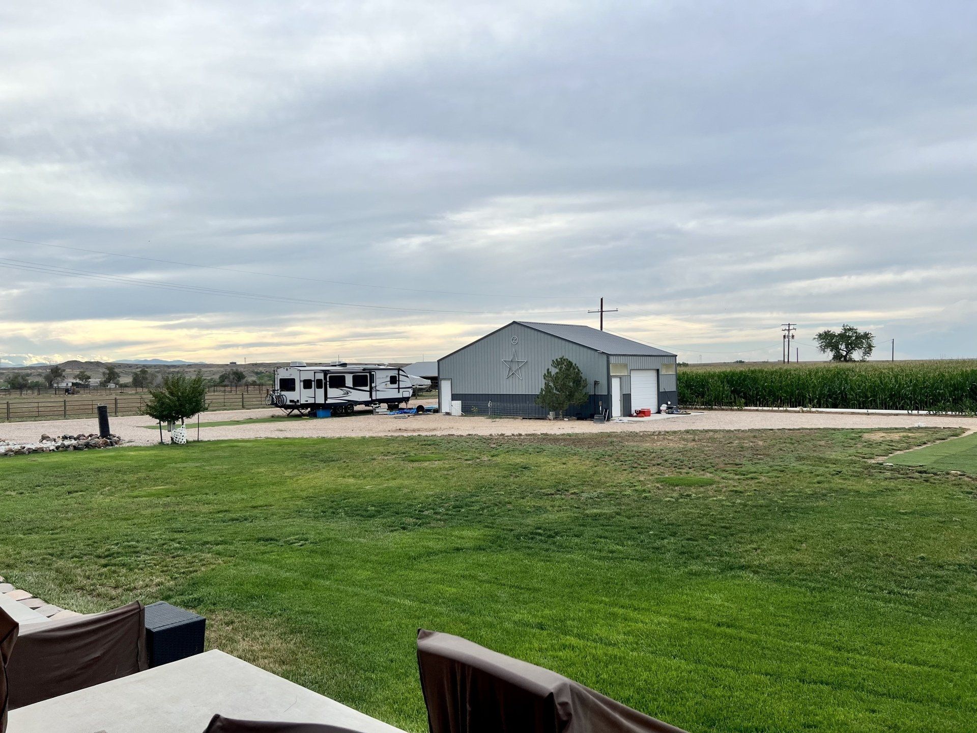 A rv is parked in a grassy field in front of a building.