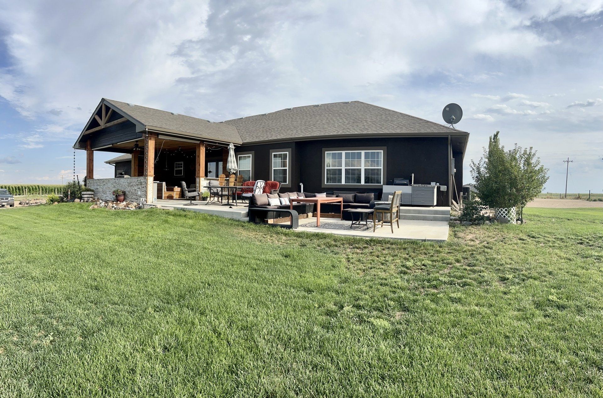 A large house is sitting in the middle of a lush green field.