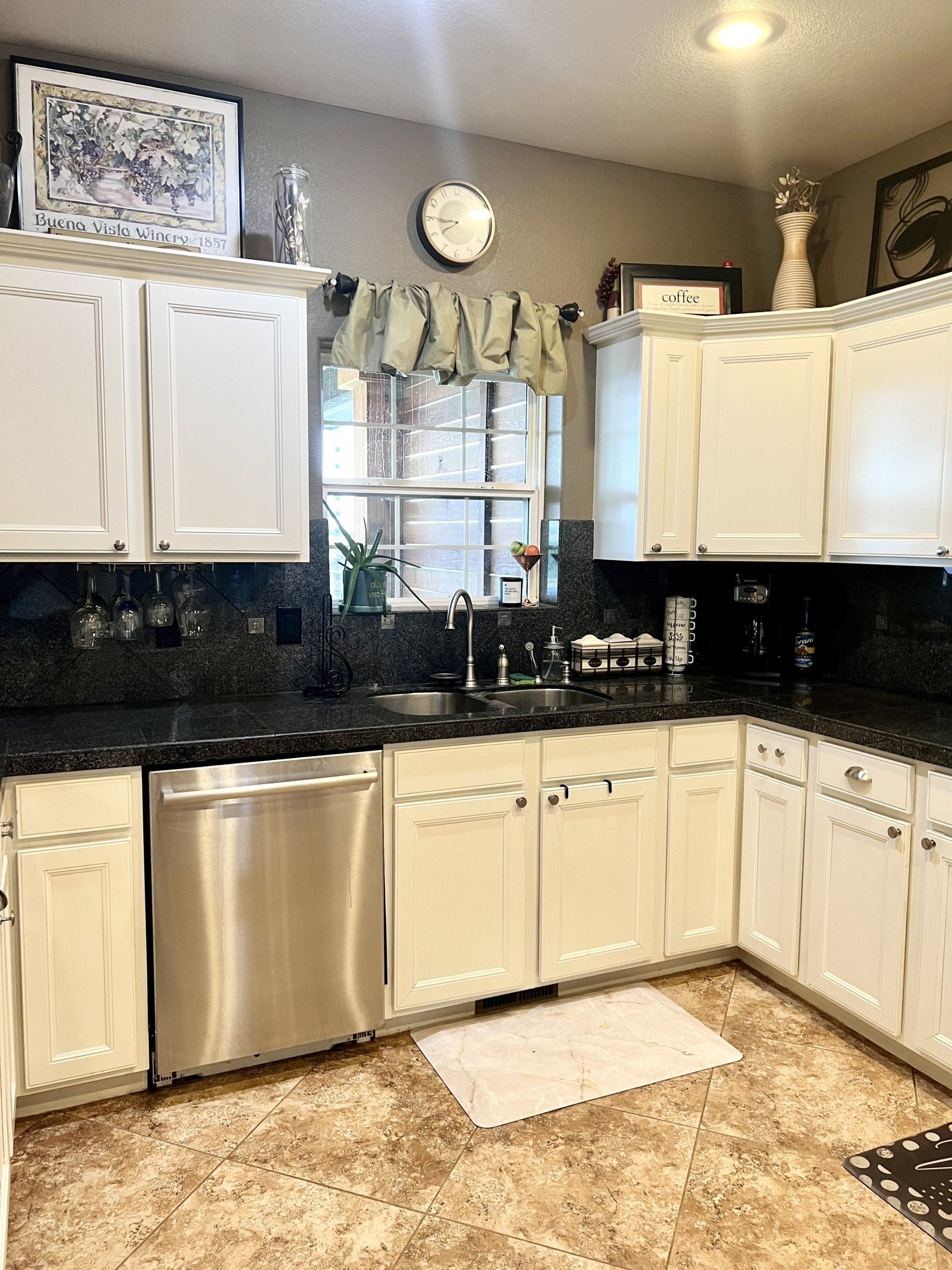 A kitchen with white cabinets and stainless steel appliances.