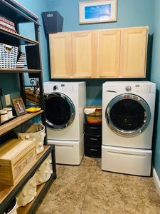 There are two washers and dryers in the laundry room.