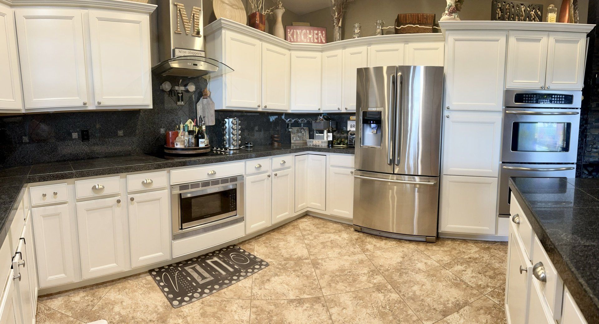 A kitchen with white cabinets and stainless steel appliances.