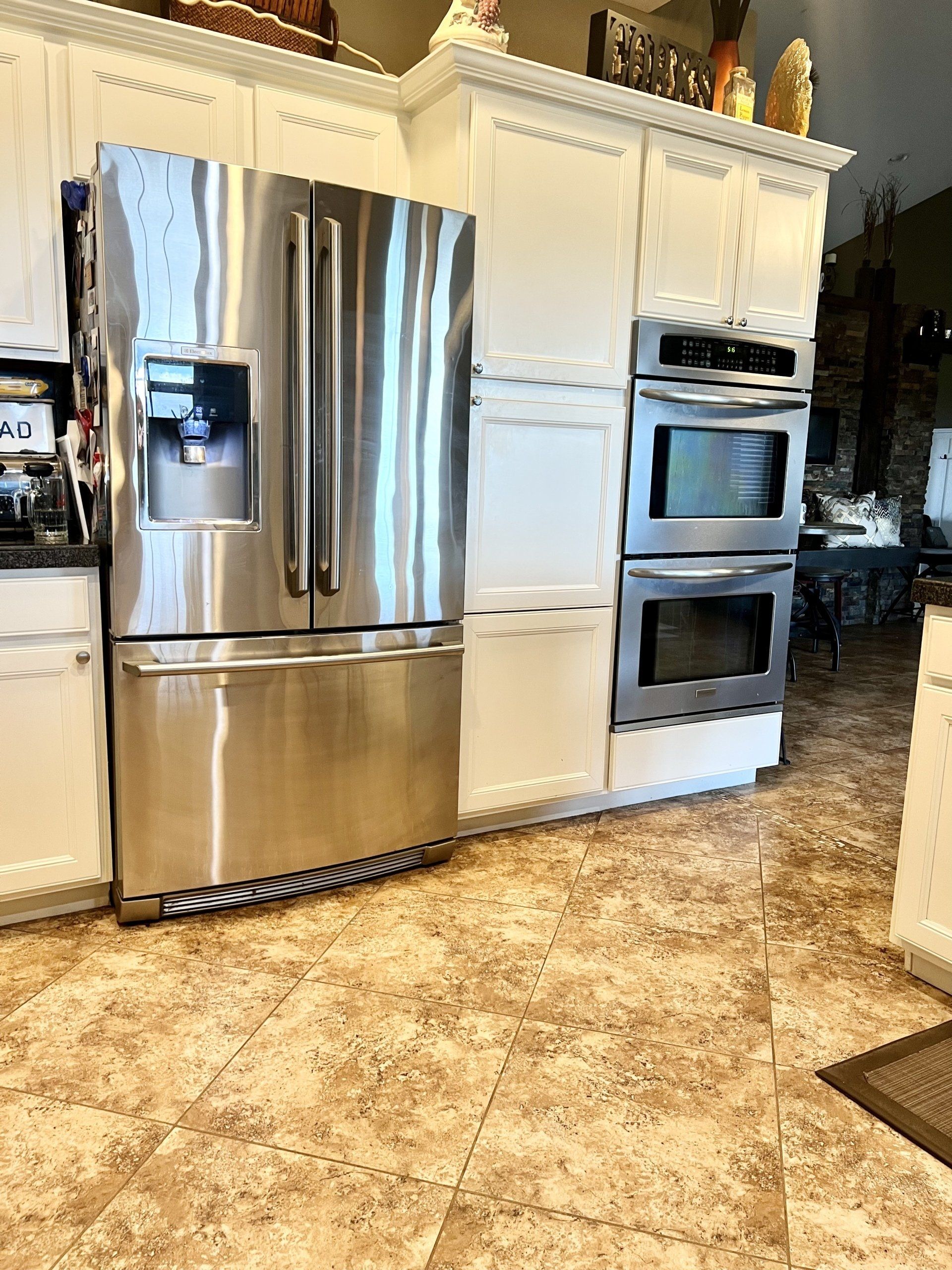 A kitchen with stainless steel appliances and white cabinets.
