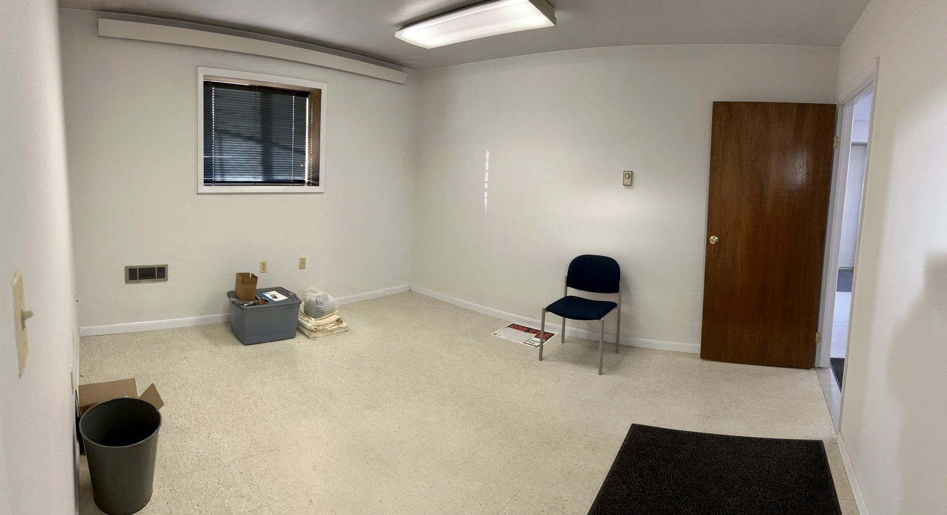 An empty room with a chair and a window