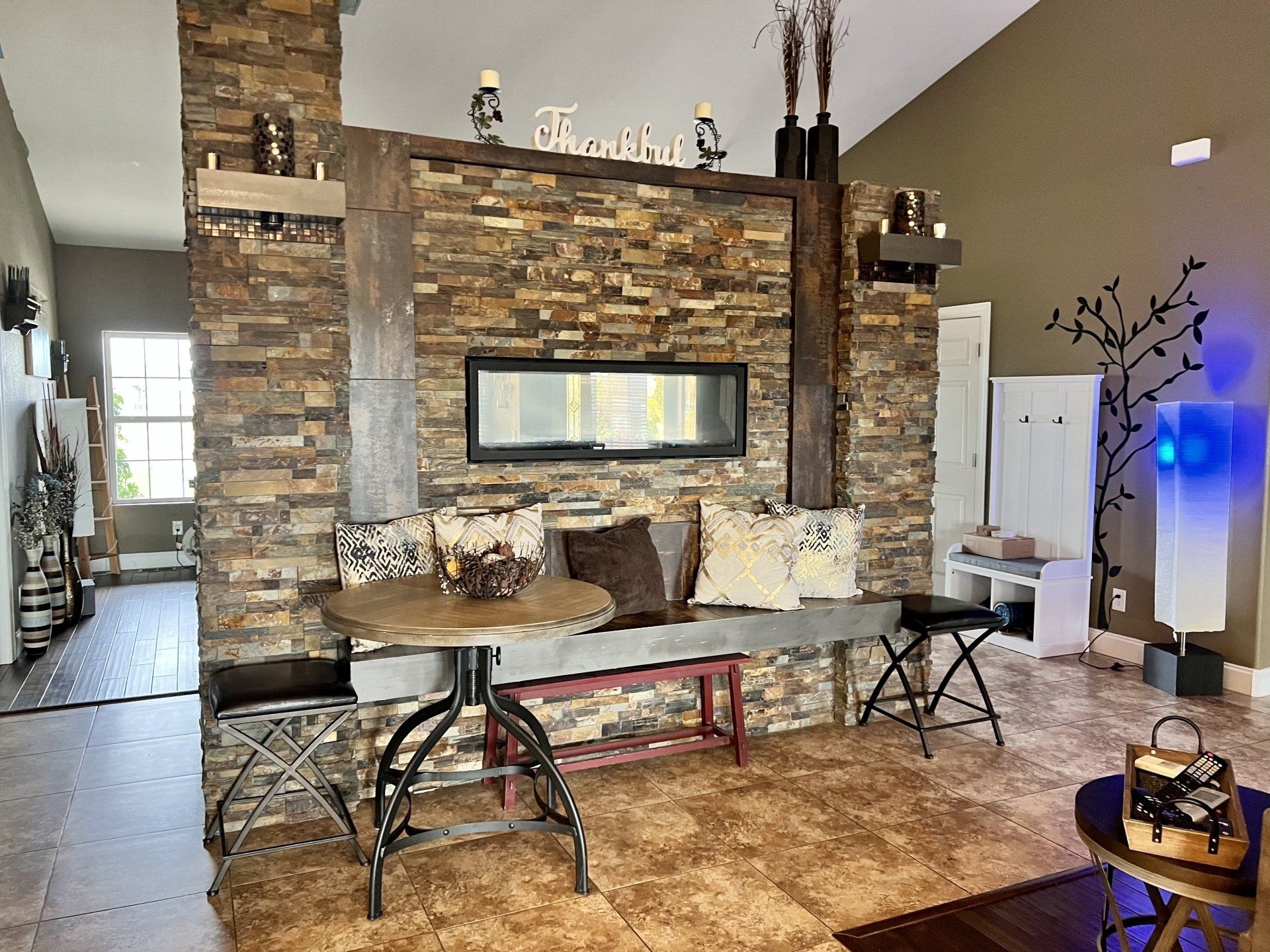 A living room with a stone wall and a fireplace.