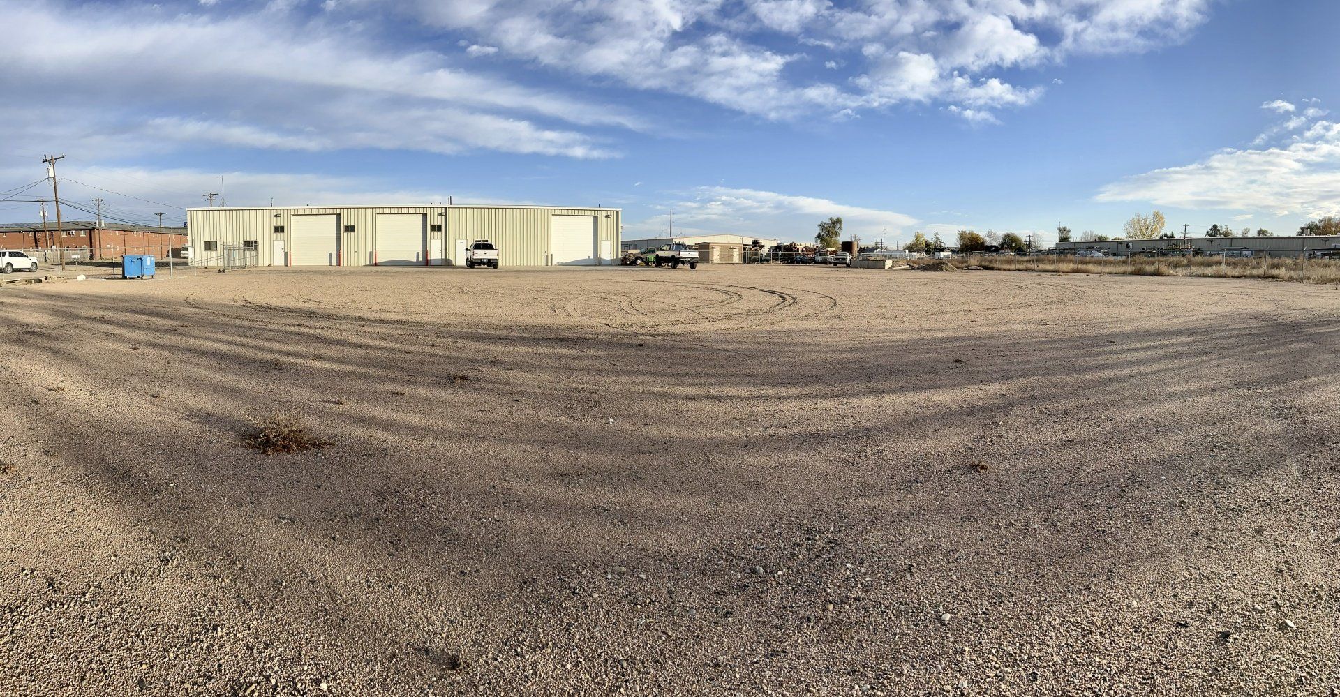 A large gravel lot with a building in the background.