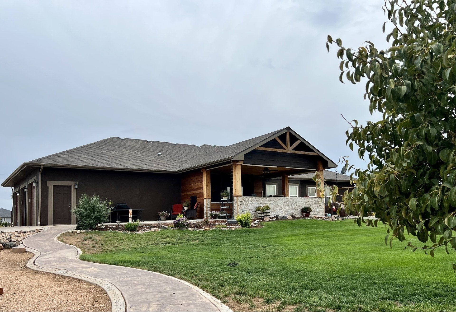 A large house is sitting on top of a lush green hill.