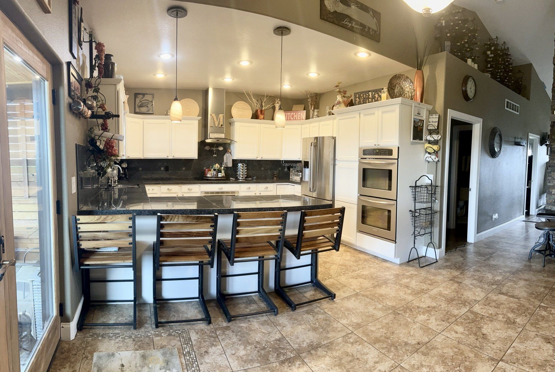 A kitchen with a bar and chairs in it