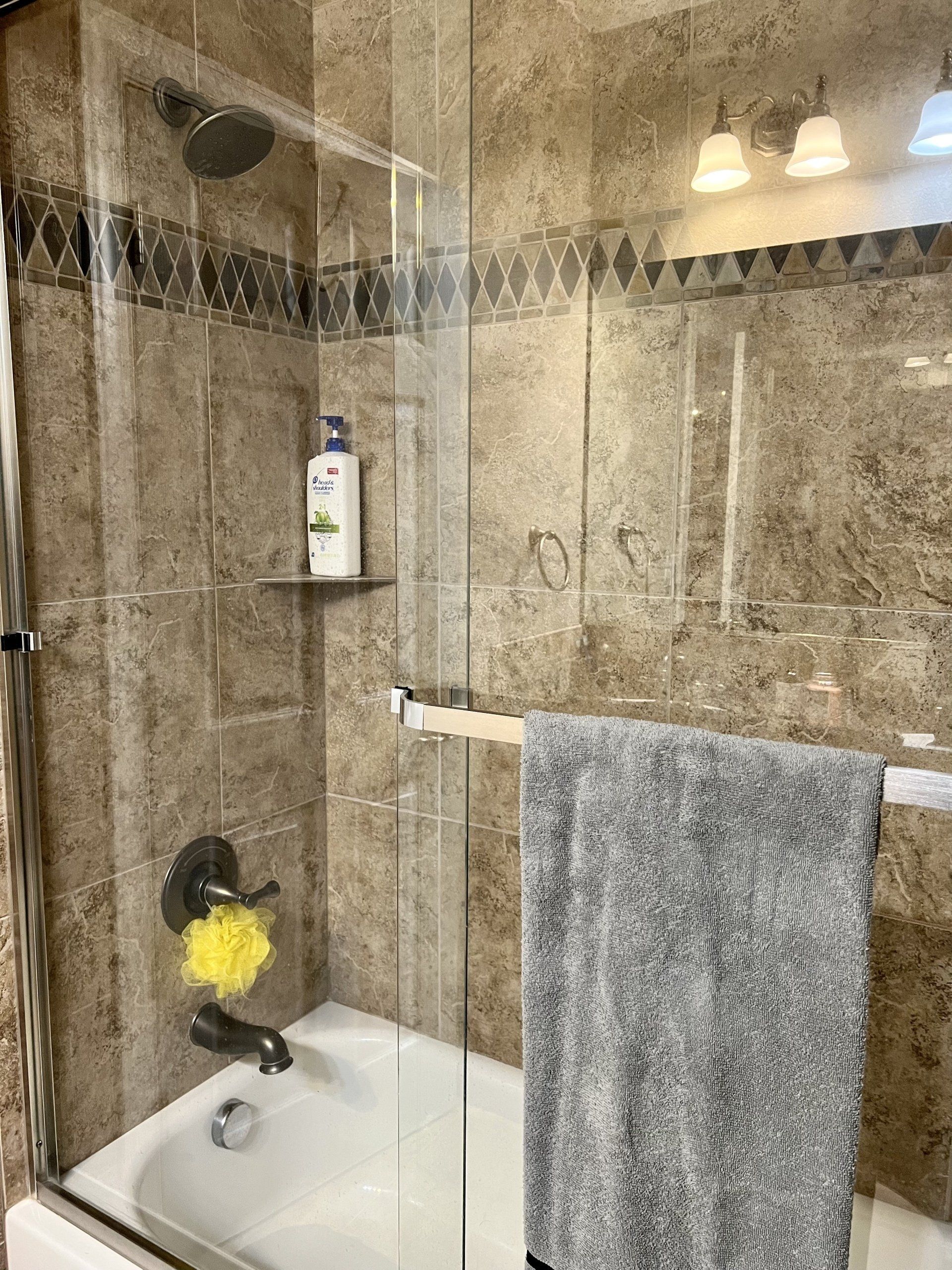 A bathroom with a bathtub , shower , and towel.