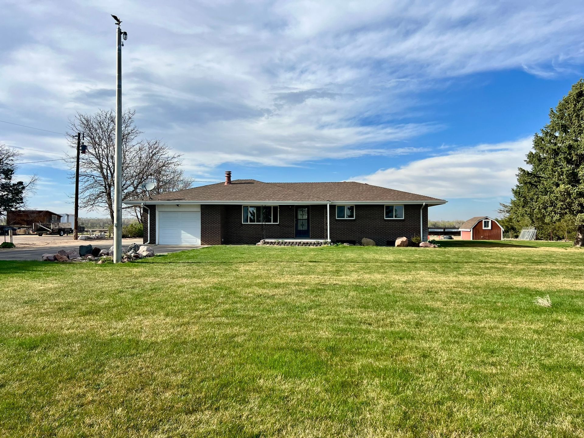 A house is sitting in the middle of a lush green field.