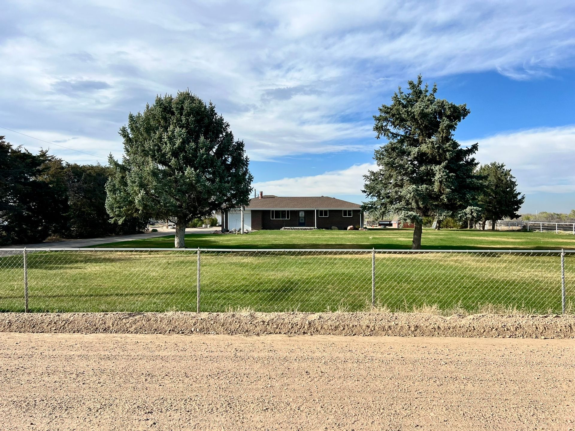 A fenced in yard with a house in the background