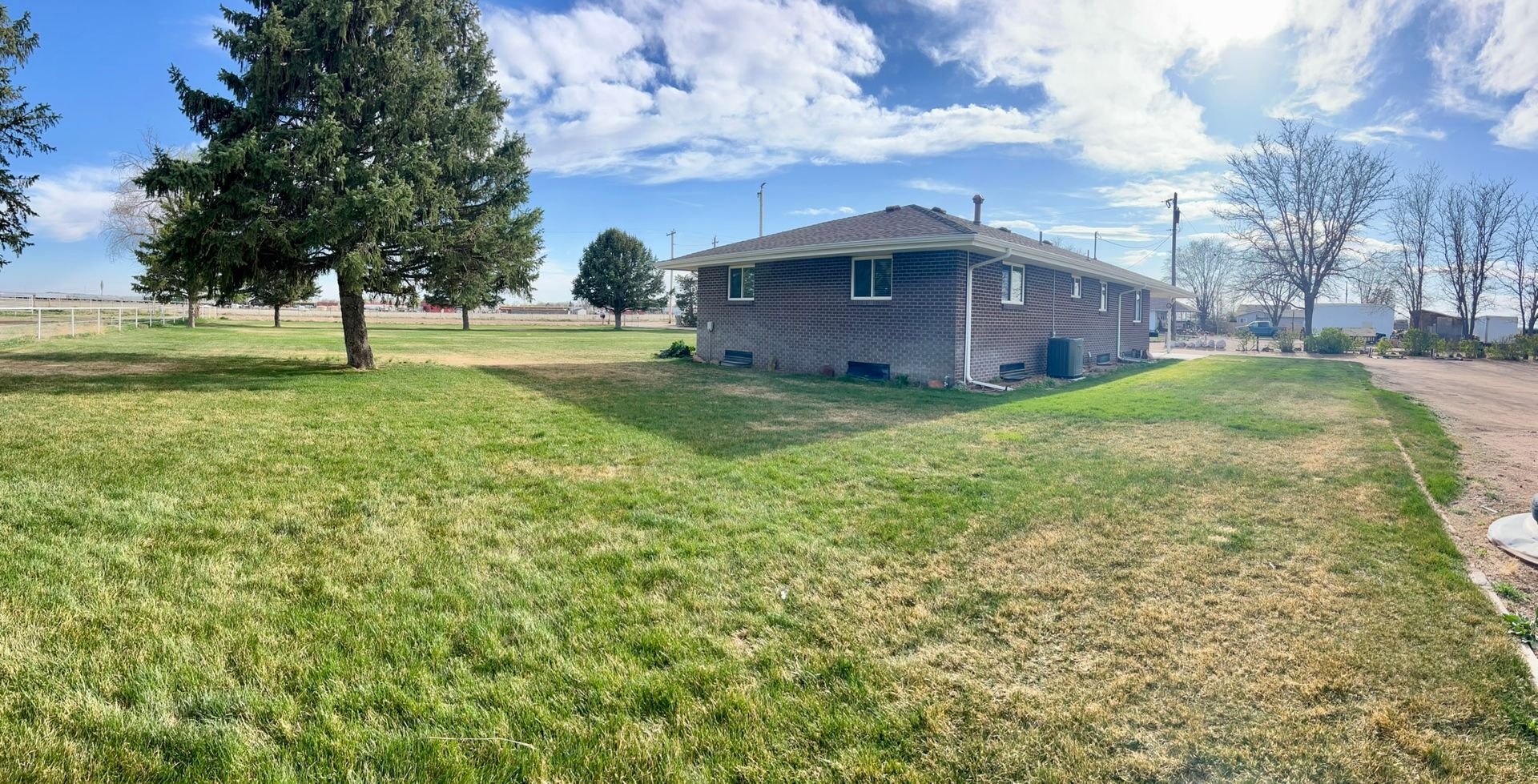 A house is sitting in the middle of a lush green field.
