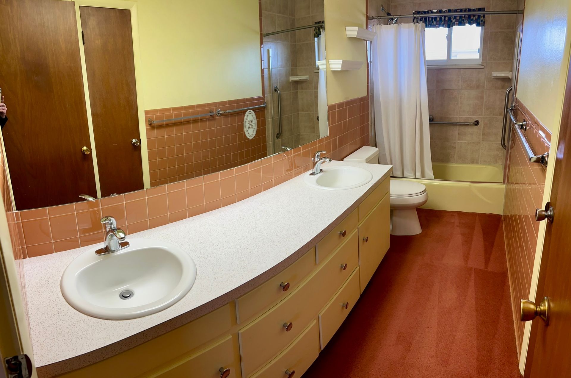 A bathroom with two sinks and a toilet